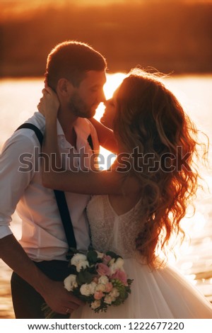 bride and groom kiss at sunset. wedding concept in nature at sunset.