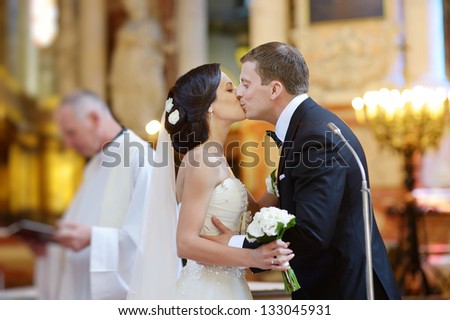 Bride and groom kissing in a church after wedding ceremony
