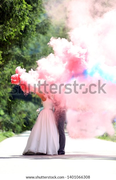 bride and groom\
kissing in the smoke\
cloud