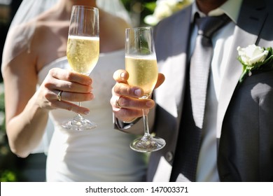 Bride And Groom Making A Toast With Champagne Glasses After Wedding Ceremony