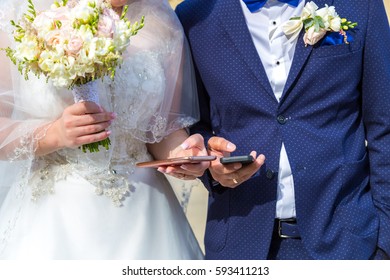 the bride and groom with mobile in hand. Modern wedding with gadgets - Powered by Shutterstock