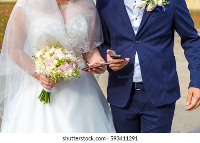 the bride and groom with mobile in hand. Modern wedding with gadgets