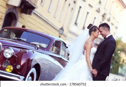 Bride and groom near vintage car