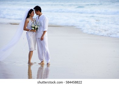 Bride and groom on beach, standing face to face - Powered by Shutterstock