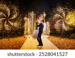 The bride and groom on wedding ceremony venue with fireworks at night. Wedding decor. professional organization of the celebration.