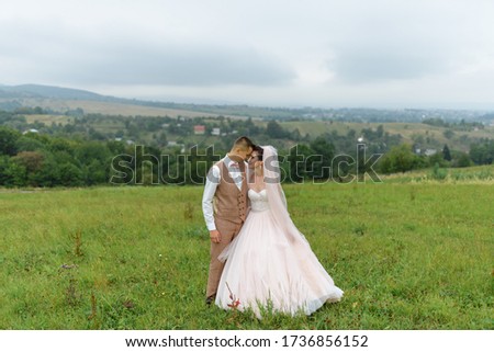 The bride and groom on a wedding walk. Loving couple hugs and look into each other's eyes. Copy space