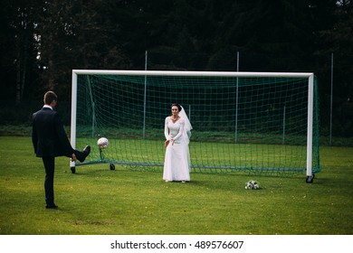 Bride and groom playing football, joke at the wedding on sunny day - Shutterstock ID 489576607
