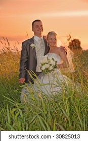 Bride and groom posing at sunset