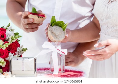 Bride And Groom Pouring Colorful Different Colored Sands Into The Crystal Vase Close Up During Symbolic Nautical Decor Destination Wedding Marriage Unity Ceremony On Sandy Beach In Front Of The Ocean 