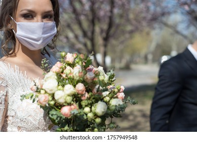bride and groom in protective masks. Wedding during the period of quarantine and pandemic Covid 19-20, coronavirus wedding. The groom and the bride in wedding dresses, with dresses in protective masks