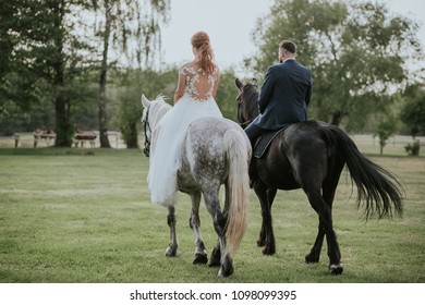 Bride and groom riding horse while their wedding photoshoot.