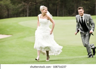 Bride And Groom Running On The Green Grass