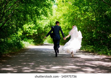 Bride And Groom Running On The Road