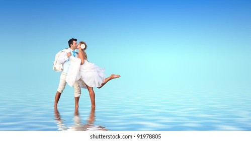 Bride and groom in the sea with water reflection