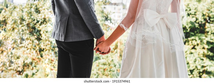 Bride and groom standing and hand in hand in the garden, love and valantine day concept.