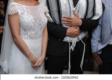 bride and groom standing on huppah