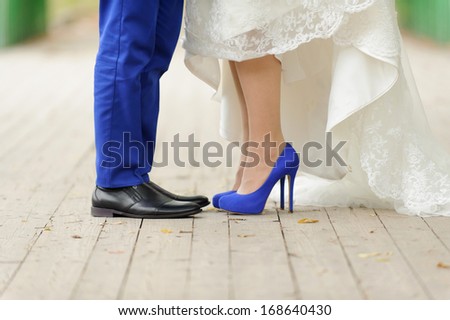 bride and groom standing on wooden bridge in park