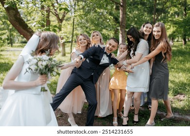 A bride and groom are surrounded by their wedding party, with the bride holding a bouquet. Scene is joyful and celebratory - Powered by Shutterstock