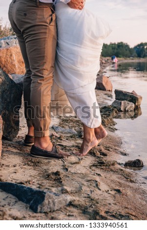 bride and groom walk barefoot on the beach