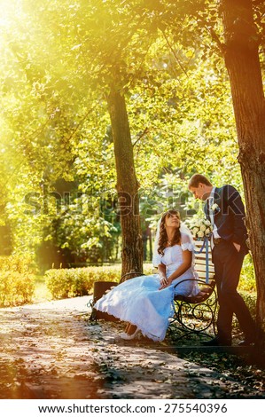 Bride and Groom at wedding Day walking Outdoors on spring nature. Bridal couple, Happy Newlywed woman and man embracing in green park. Loving wedding couple outdoor.