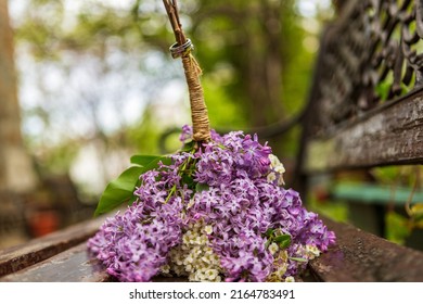 Bride And Groom. Wedding Ring And Wedding Bouquet. Spring Summer Celebration. He Puts A Ring On Her Hand. Blue Wedding Suit. Purple Bouquet And Gold Rings.