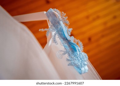 bride and groom's wardrobe and items of clothing blue bridal garter on clothes hanger - Powered by Shutterstock