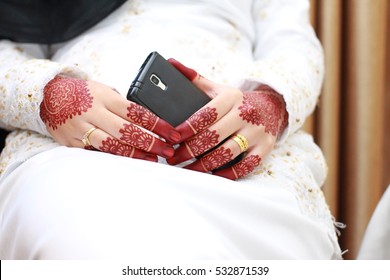 Bride With Henna Hand Carving Was Holding A Cell Phone. Closeup