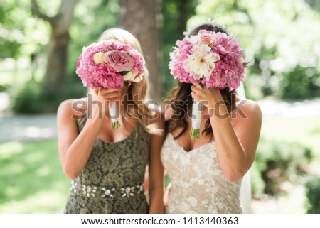 Bride and her bridesmaid with flower on their face