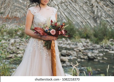 Bride Holding Colorful Elegant Modern Autumn Wedding Bouquet In Red, Marsala, Burgundy For A Fall Wedding