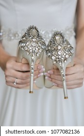 A bride holding gorgeous wedding shoes