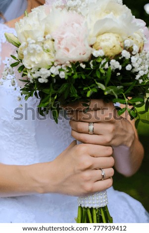 A bride holding a paeonia wedding bouqet in her hands