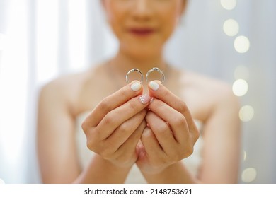 Bride holding Wedding Rings on both hands  - Shutterstock ID 2148753691