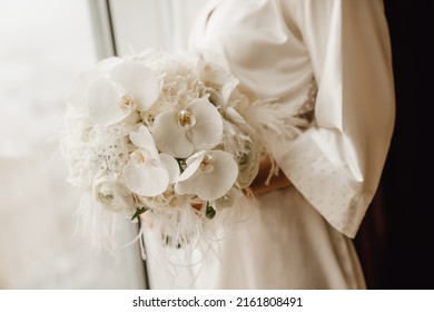 Bride holding wedding white orchid bouquet