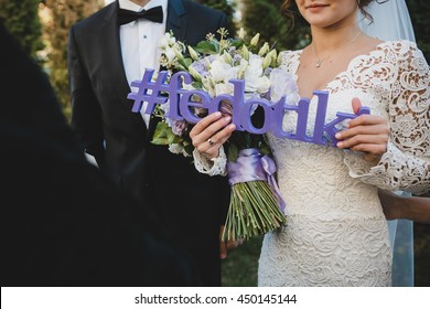 Bride Holds In Her Hands A Violet Letteing With Wedding Hashtag