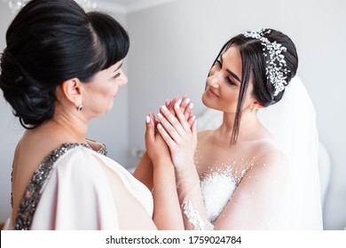 The bride holds her mother's hands on the wedding day. The concept of the relationship between mothers and daughters - Powered by Shutterstock