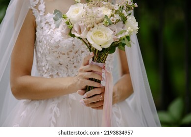 The Bride Holds A Wedding Bouquet Of Flowers At The Ceremony. The Bride Holds A Bouquet In Hands. The Bride Is Holding A Wedding Bouquet, Wedding Dress, Wedding Details.