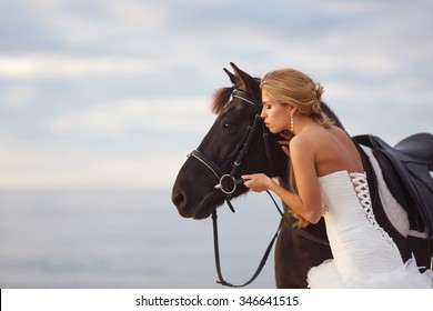 Bride with a horse by the sea in their wedding day