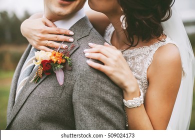 Bride Hugging A Groom And The Details Of Their Outfit: Bracelet And A Buttonhole