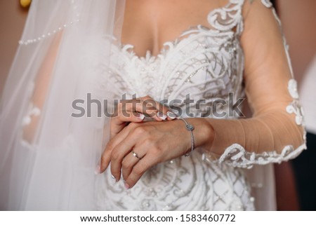 Bride jewls on hand, ready for wedding ceremony. White dress and caucasian skin.