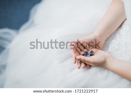 Bride is keeping in hands blue wedding acessories 