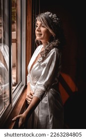 bride looking out the window dressed in white