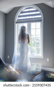 Bride looking out the window on wedding day