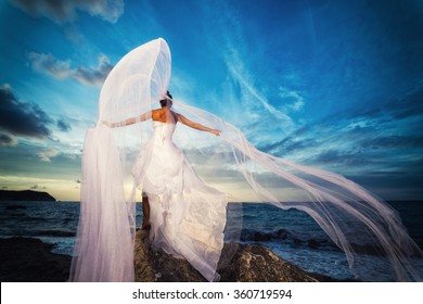 bride on a tropical beach with the sunset in the background