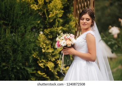 Bride In Park With Bouquet. Spring. Sunny Weather.