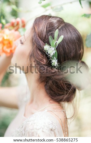 Bride in the park. The girl is turned, dancing. The hair of the girl wreath of flowers. Outdoors.