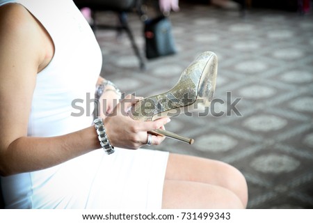 A bride playing wedding games with her high heel shoes at her reception.
