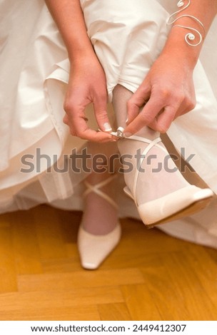 The bride puts on her shoes. Bride wearing shoes. Beautiful bride is getting ready for her wedding. Wedding shoes. the bride puts on her shoes in the morning. Wedding Day details.