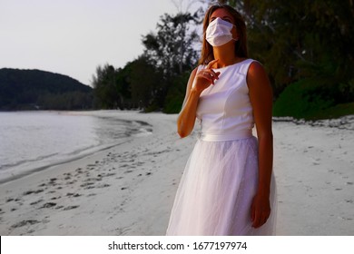 Bride with respirator mask on the tropical beach. corona virus. covid-19 protecting. Samui beautiful beach.    the women in wite dress and wite respirator mask.       