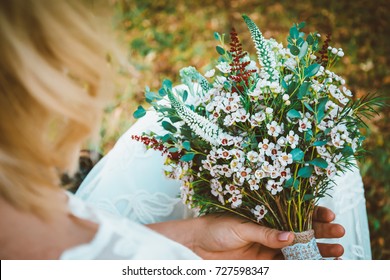 Bride showing off her beautiful boho flowers bouquet. Boho / vintage image with copy space for: amazing boho wedding flowers, bohemian dress,
women fashion, florist and other related subjects.