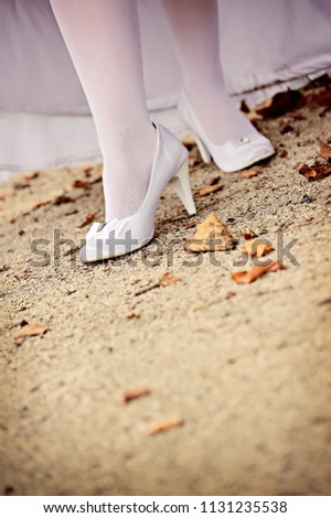 Bride showing white legins and white wedding shoes